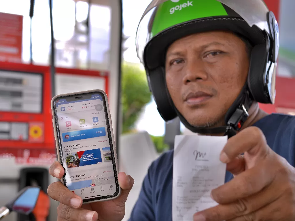 Salah satu ojek daring memperlihatkan aplikasi My Pertamina untuk transaksi pengisian bahan bakar di salah satu Stasiun Pengisian bahan bakar Umum (SPBU) di Manado, Sulawesi Utara, Jumat (3/4/2020). (photo/ANTARA FOTO/Adwit B Pramono)