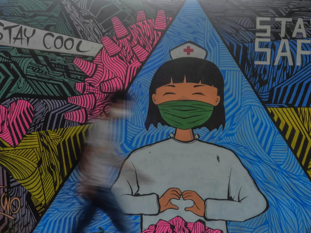 Warga melintas di depan mural tentang pandemi virus corona atau COVID-19 di Kabupaten Ciamis, Jawa Barat. (ANTARA/Adeng Bustomi)