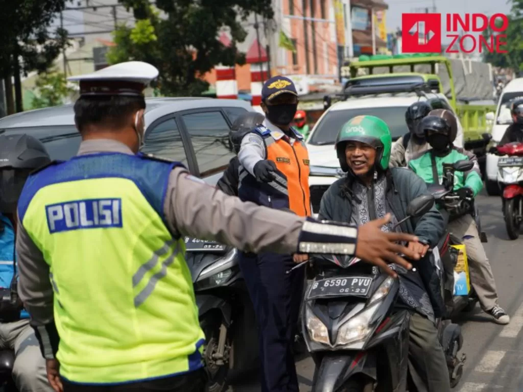 Petugas menghimbau pengguna kendaraan bermotor saat melakukan Pengawasan Pelaksanaan PSBB. (INDOZONE/Arya Manggala)