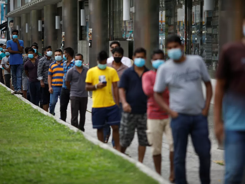 Pekerja migran di Singapura berbaris untuk mendapatkan bantuan makanan (REUTERS/EDGAR SU)