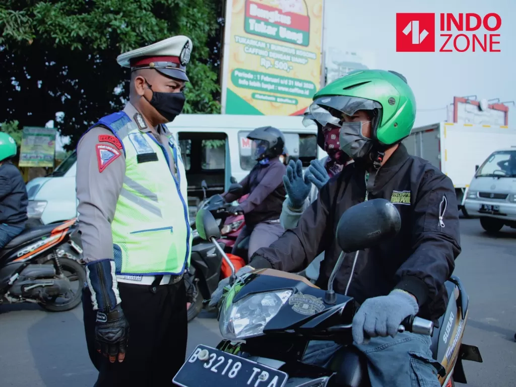 Petugas mengimbau pengguna kendaraan bermotor saat melakukan Pengawasan Pelaksanaan PSBB di Jalan Jatiwaringin, Bekasi, Jawa Barat. (INDOZONE/Febio Hernanto)