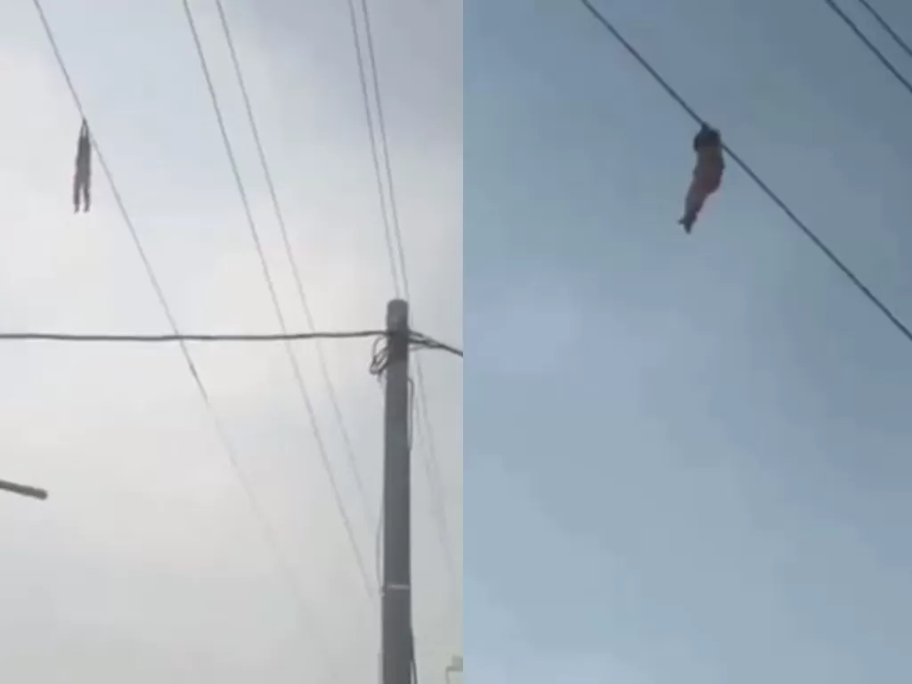 Seorang bocah bergelantungan di kabel sutet setinggi 15 meter. (Screenshot)
