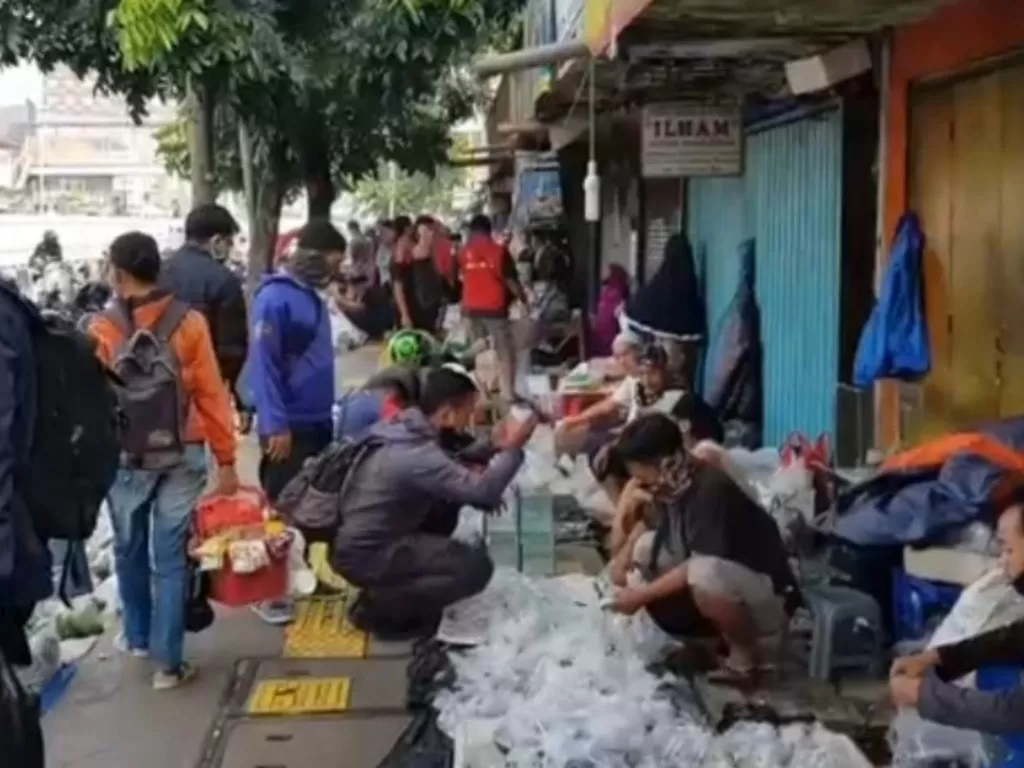 Konsumen dan pedagang berkerumun di Pasar Ikan Jatinegara yang menempati trotoar Jalan Raya Matraman, Jakarta Timur, Minggu (19/4/2020). (ANTARA/Satpol PP Jatinegara).