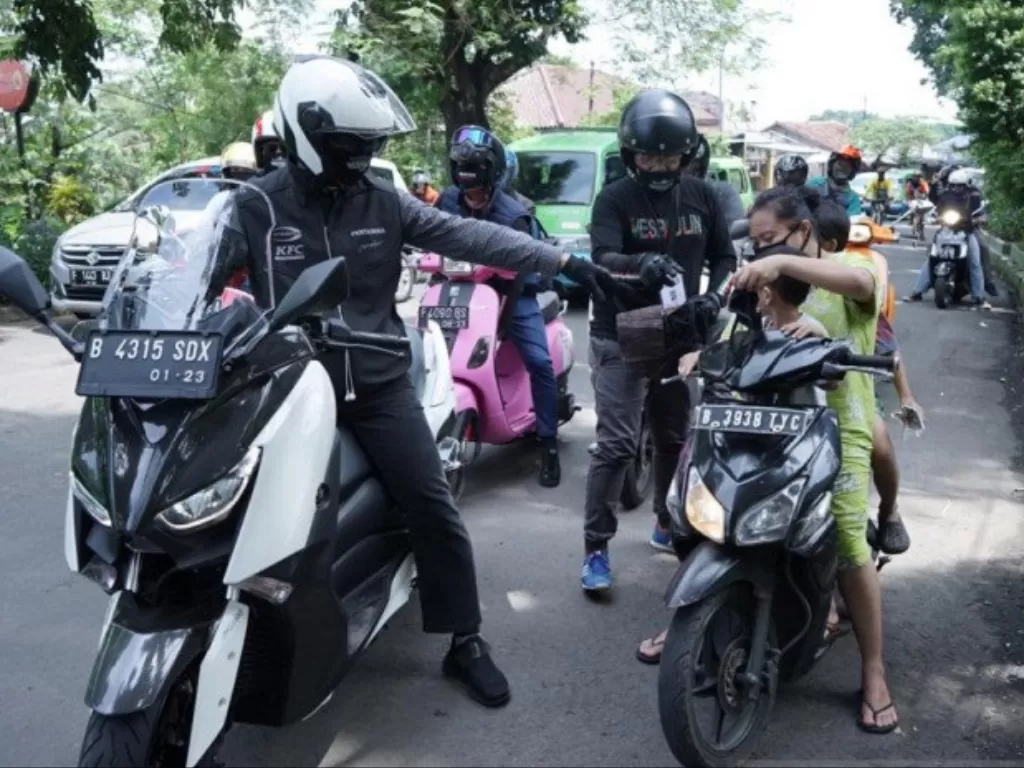 Wakil Wali Kota Bogor Dedie A Rachim yang menggunakan sepeda motor, memberikan masker dan peringatan kepada warga yang melanggar aturan PSBB di Kota Bogor, Minggu (19/4/2020). (Photo/ANTARA/HO/Pemkot Bogor)