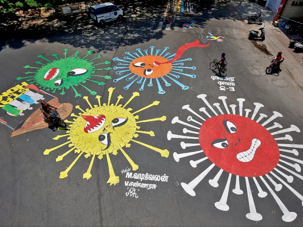 Orang-orang melewati grafiti di jalan yang menggambarkan virus corona sebagai upaya untuk meningkatkan kesadaran tentang pentingnya tinggal di rumah di Chennai, India, . (Photo/REUTERS/P. Ravikumar)