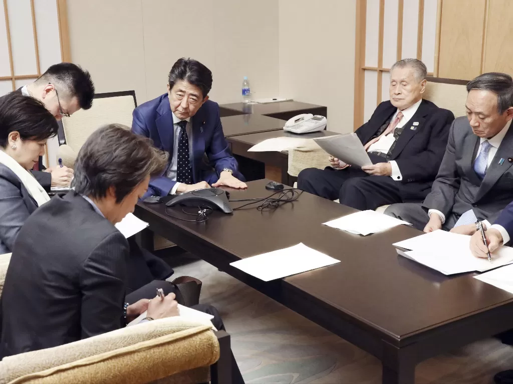 PM Jepang Abe menghadiri konferensi telepon dengan Presiden IOC Bach di Tokyo. (Photo/REUTERS/Kyodo)