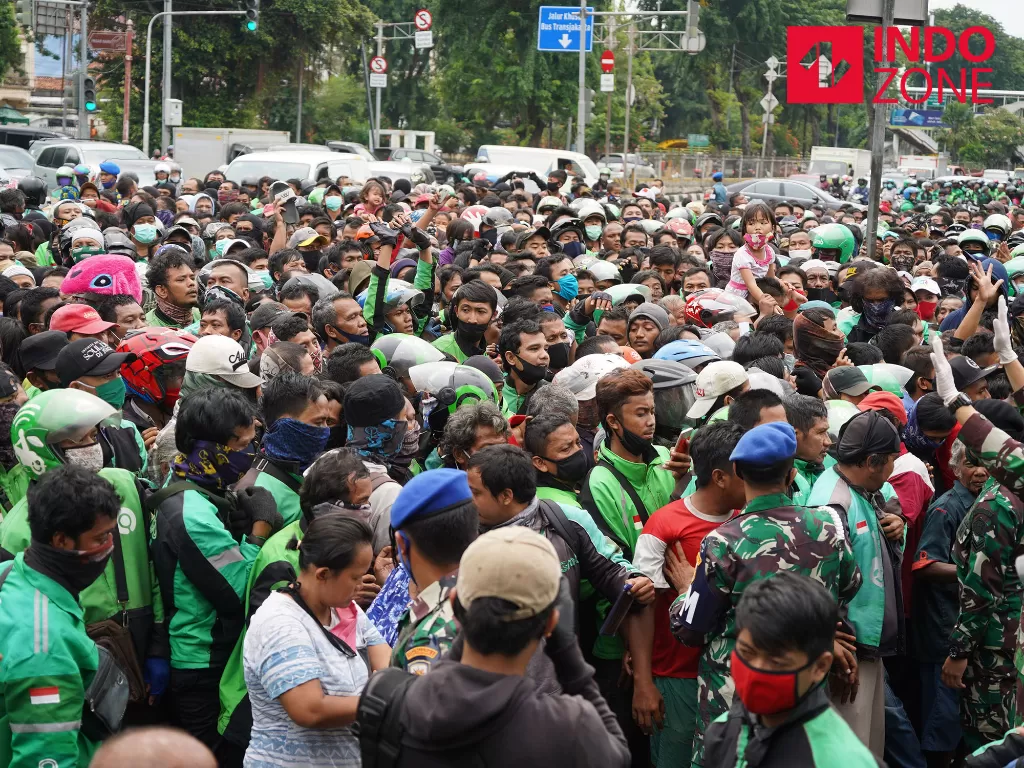 Warga antre mendapatkan nasi kotak dan masker di Markas Komando Gabungan Wilayah Pertahanan (Kogabwilhan) I, Jakarta, Selasa (21/4/2020). (INDOZONE/Arya Manggala)