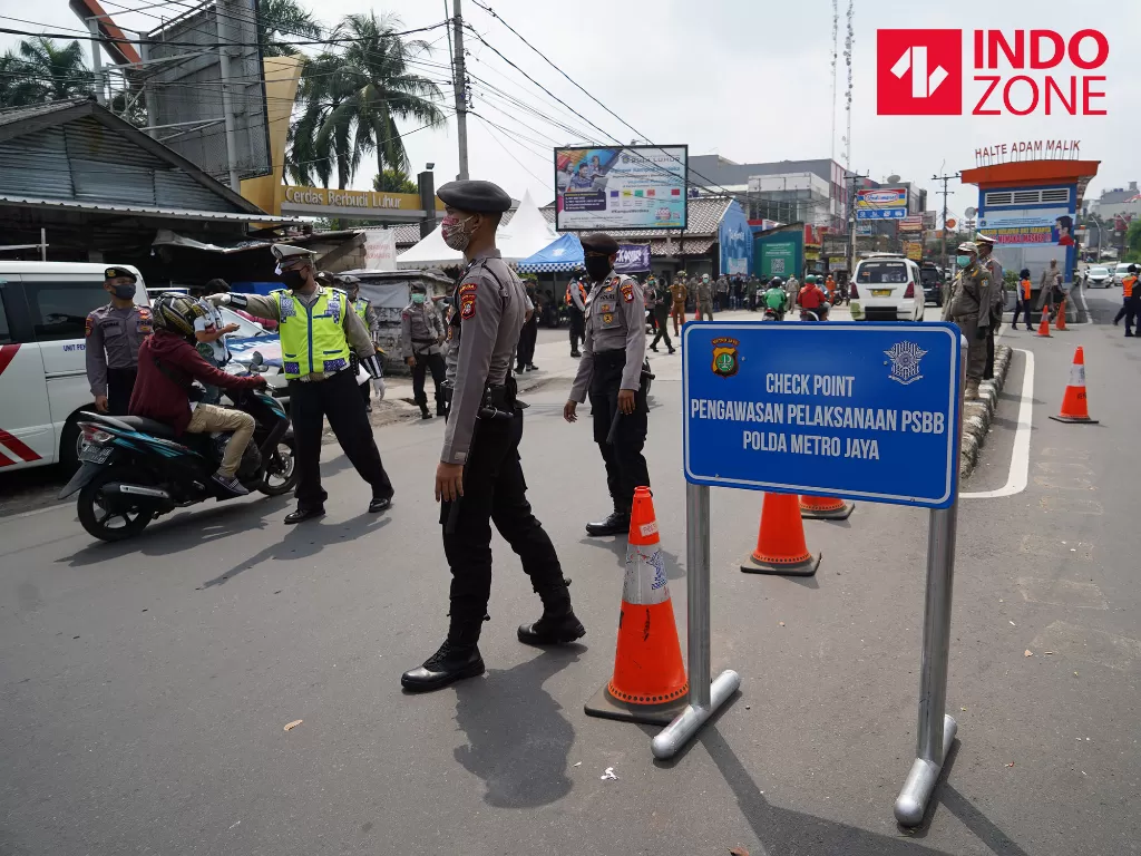 Petugas menghimbau pengguna kendaraan bermotor saat melakukan Pengawasan Pelaksanaan PSBB di Jalan Ciledug Raya, Jakarta, Senin (13/4/2020). (INDOZONE/Arya Manggala)