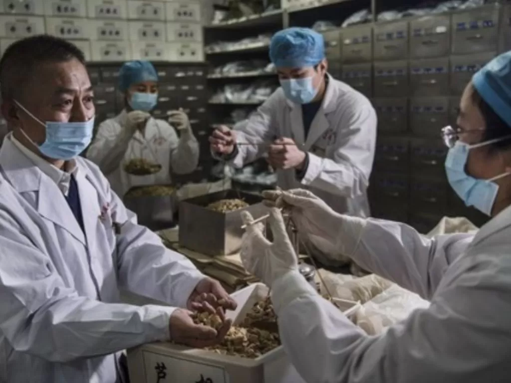 Petugas medis bekerja di sebuah apotek obat tradisional China di Kota Weinan, Provinsi Shaanxi, China barat laut, pada 20 Februari 2020. (Xinhua/Tao Ming)