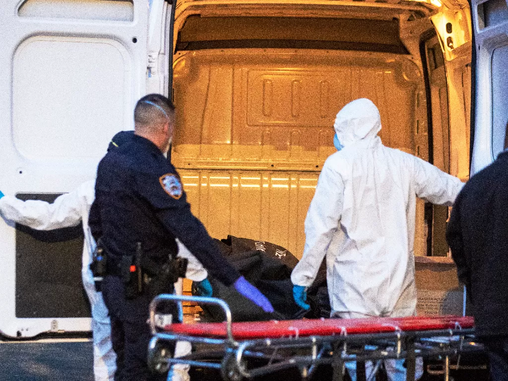 Staf medis dan polisi membawa korban meninggal diduga karena corona di New York, AS. (REUTERS/Lucas Jackson)