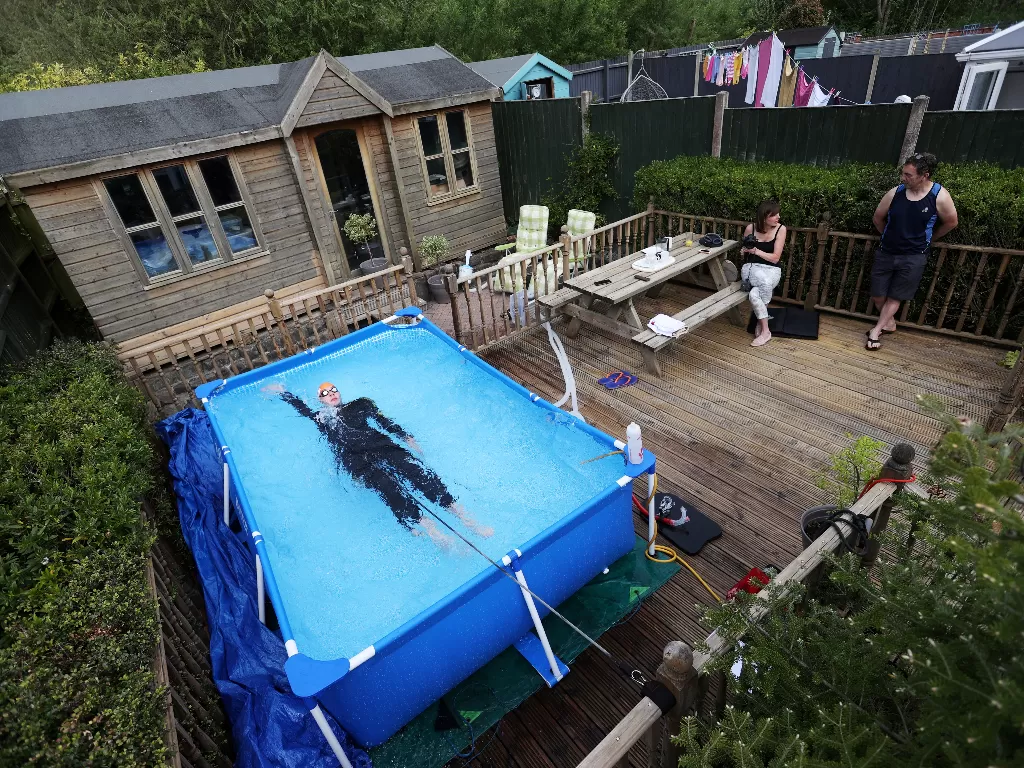  Atlet triathlon Lloyd Bebbington berlatih di kolam di kebun rumahnya untuk menjaga kebugaran saat pandemi COVID-19, di Newcastle-under-Lyme, Inggris, 26 April 2020. (REUTERS/Carl Recine)