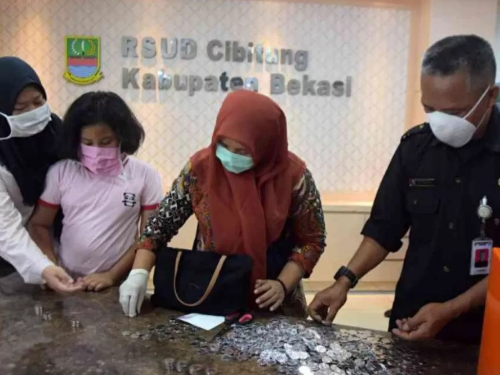 Kakak beradik bernama Tania Amelinda (15) dan Maulida Lailatul (9) membantu mengumpulkan uang dari celengan mereka untuk disumbangkan ke RSUD Kabupaten Bekasi. (ANTARA/Pradita Kurniawan Syah)