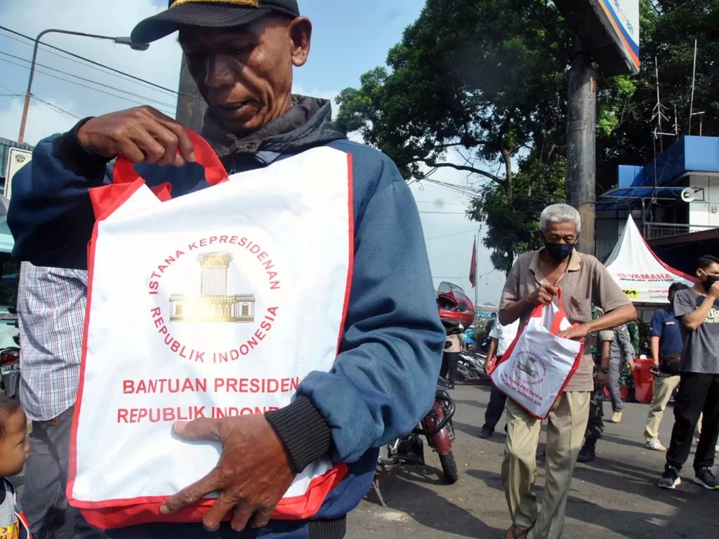 Warga menerima bantuan sembako dari Presiden Joko Widodo di Terminal Baranangsiang, Kota Bogor, Jawa Barat. (Photo/ANTARA FOTO/Arif Firmansyah)