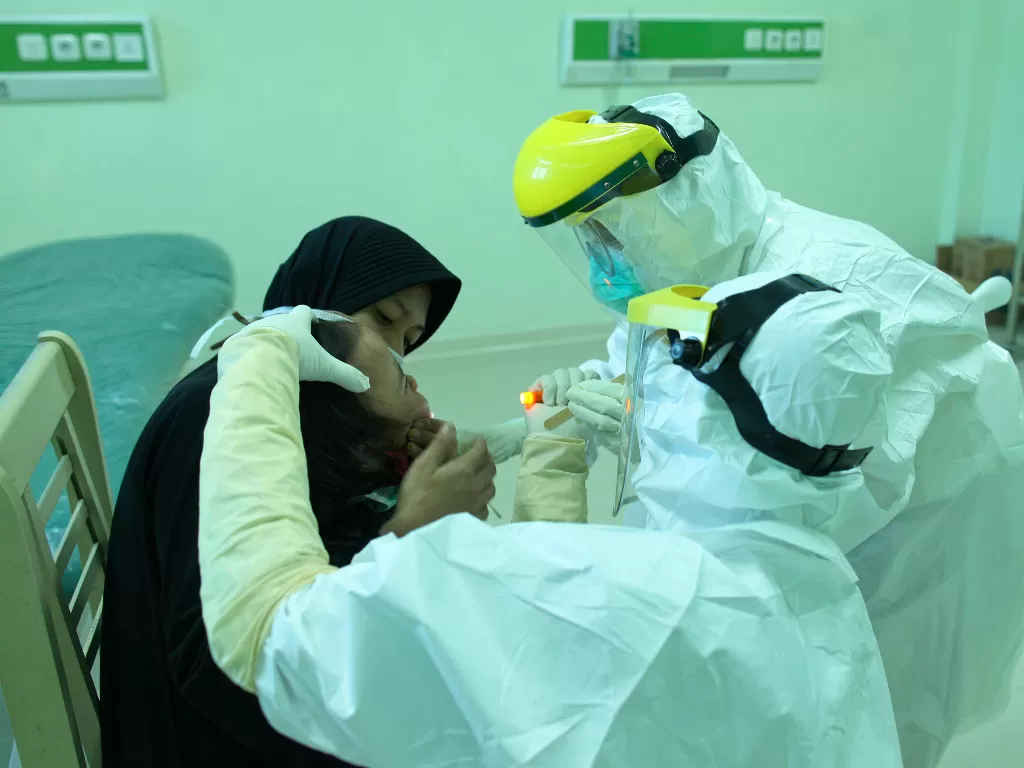 Petugas medis melakukan tes swab kepada warga. (ANTARA FOTO/Fachrurrozi)