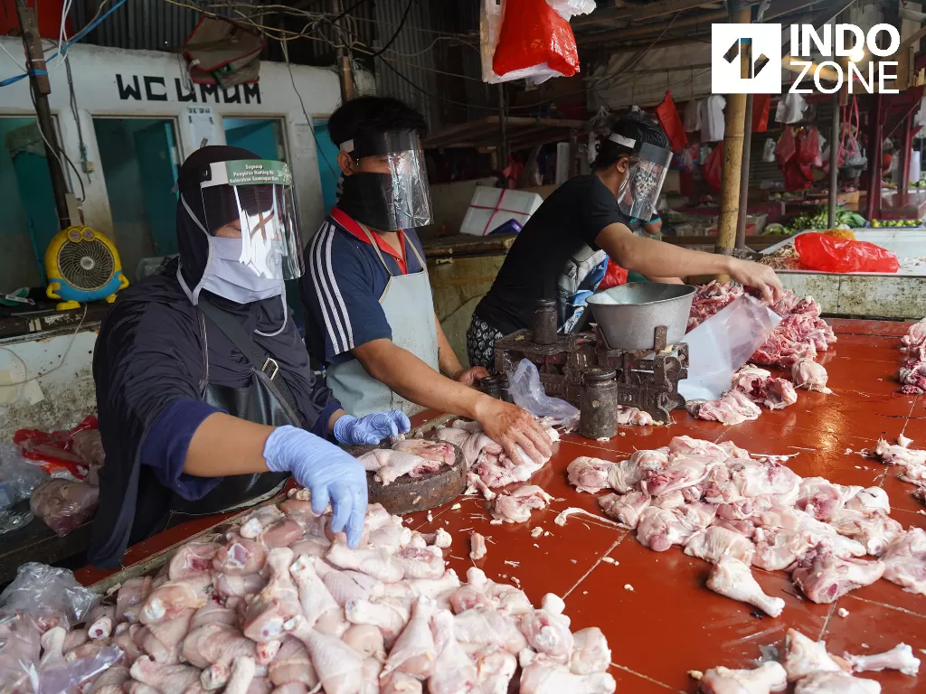 Pedagang daging ayam menggunakan plastik pelindung wajah saat berjualan di Pasar Kemiri Muka, Depok, Jawa Barat, Jumat (1/5/2020). (INDOZONE/Arya Manggala)