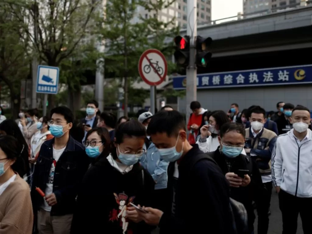 Warga di Beijing, Tiongkok, menggunakan masker sebagai pencegahan virus corona. (REUTERS/Thomas Peter)