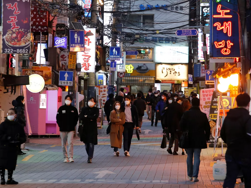 Para pejalan kaki mengenakan masker saat berjalan di sebuah pedestrian di pusat kota Seoul, Korea Selatan. (REUTERS/Heo Ran)