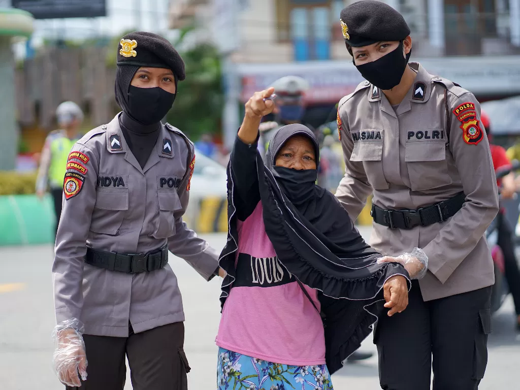 Sejumlah polisi wanita (polwan) menuntun seorang nenek menyeberang jalan. (Foto ANTARAAdiwinata Solihin)