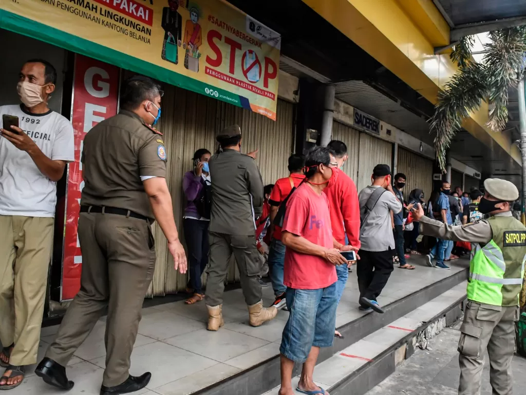 Petugs Satpol PP membubarkan aktivitas masyarakat di pusat pertokoan dalam rangka mencegah penyebaran corona di kawasan Glodok, Jakarta(ANTARA FOTO/Muhammad Adimaja)
