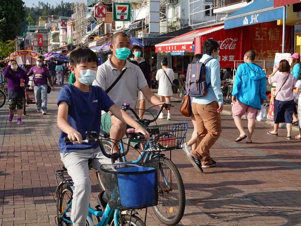 Orang-orang yang memakai masker wajah terlihat di pulau Cheung Chau selama akhir pekan Paskah, di tengah wabah penyakit COVID-19 yang baru, di Hong Kong. (Photo/REUTERS/Joyce Zhou)