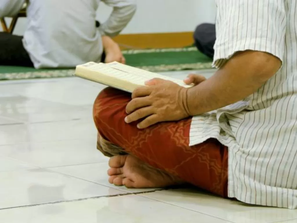 Ilustrasi seseorang membaca Alquran di bulan Ramadan (Unsplash/@utsmanmedia)