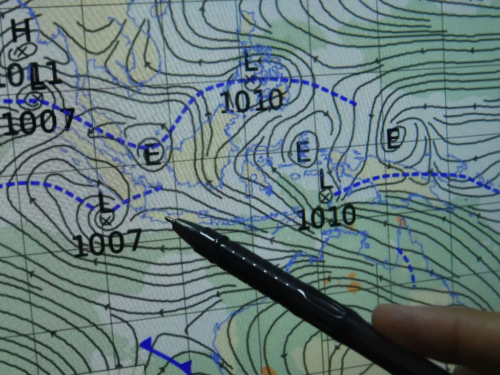 Petugas Badan Meteorologi Klimatologi dan Geofisika (BMKG) menunjukkan peta sirkulasi udara siklonik. (ANTARA/Asep Fathulrahman)