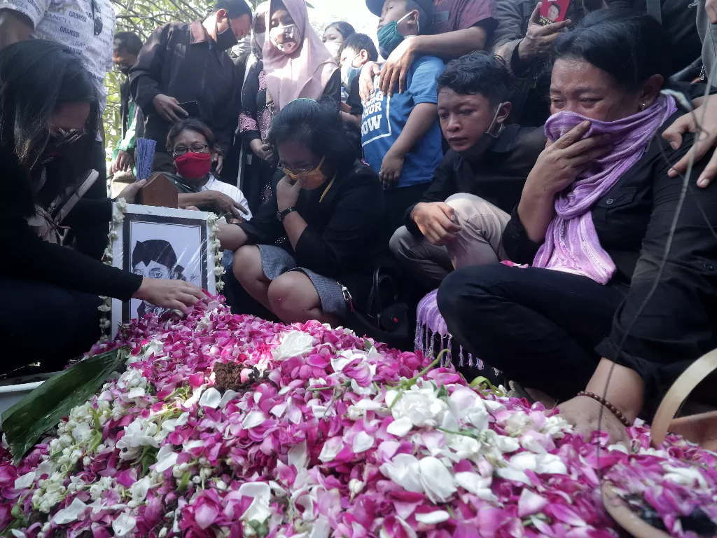 Kerabat meratapi pusara almarhum penyanyi campursari Dionisius Prasetyo atau Didi Kempot seusai dimakamkan di TPU Desa Majasem, Ngawi, Jawa Timur, Selasa (5/5/2020). (ANTARA FOTO/Joni Pratama)