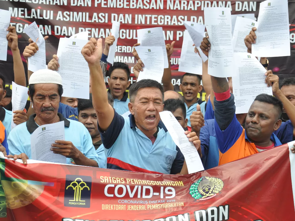 Sejumlah narapidana memperlihatkan surat pembebasan dari masa pidana di Lapas Kelas I Tanjung Gusta Medan. (Photo/ANTARA FOTO/Septianda Perdana)