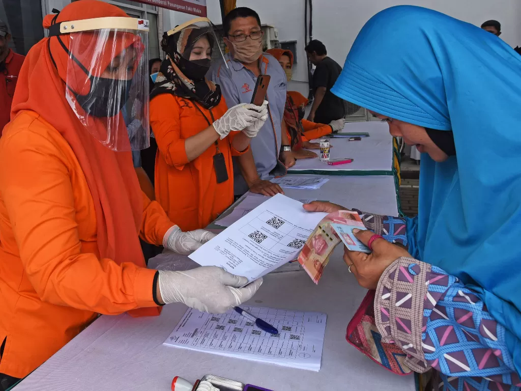 Petugas Kantor Pos menyerahkan bukti verifikasi pemberian bantuan sosial tunai (BST) kepada warga penerima manfaat di Kantor Pos Serang, Banten, Rabu (6/5/2020). (ANTARA FOTO/Asep Fathulrahman)