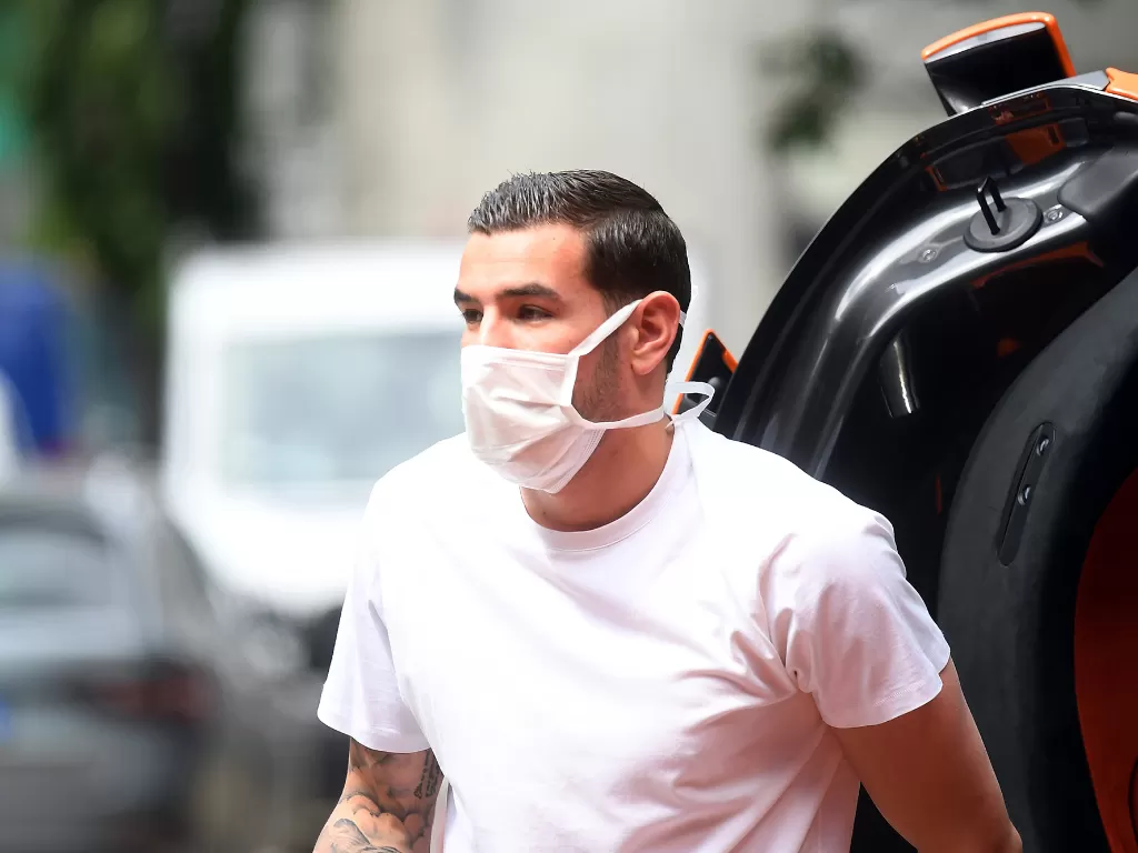 Pemain AC Milan Theo Hernandez menggunakan masker tiba di rumah sakit untuk menjalani tes medis di Milan, Selasa (5/5/2020). (REUTERS/Daniele Mascolo)
