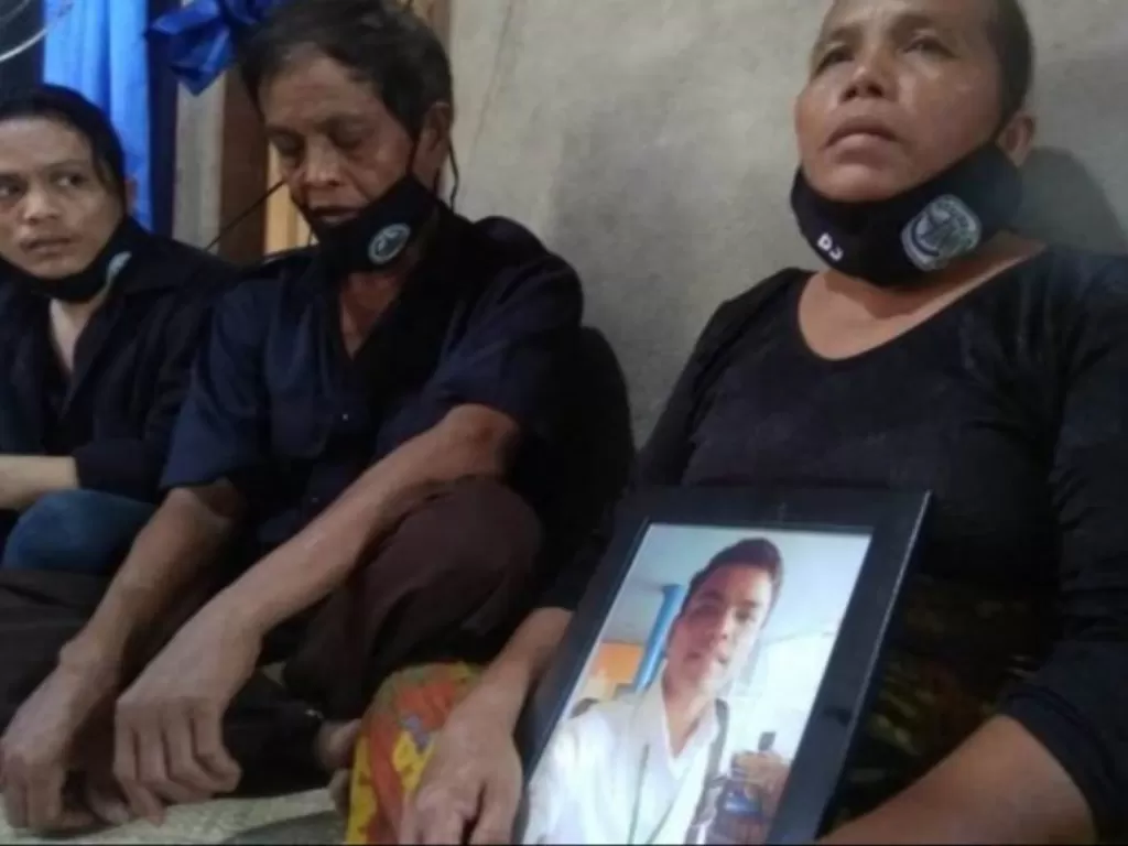Ibu almarhum Efendi Pasaribu, ABK Long Xing 629, yang meninggal di Korea Selatan, saat memengang foto anaknya sebelum dikebumikan Senin (11/5/2020) di TPU Sorkam, Kabupaten Tapanuli Tengah, Sumatera Utara. (ANTARA/HO)