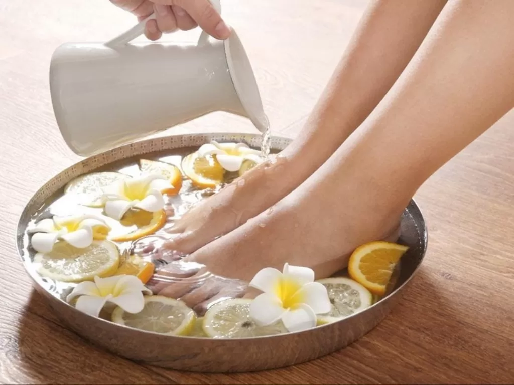 Ilustrasi merendam kaki dengan air lemon. (Allbeauty.news)