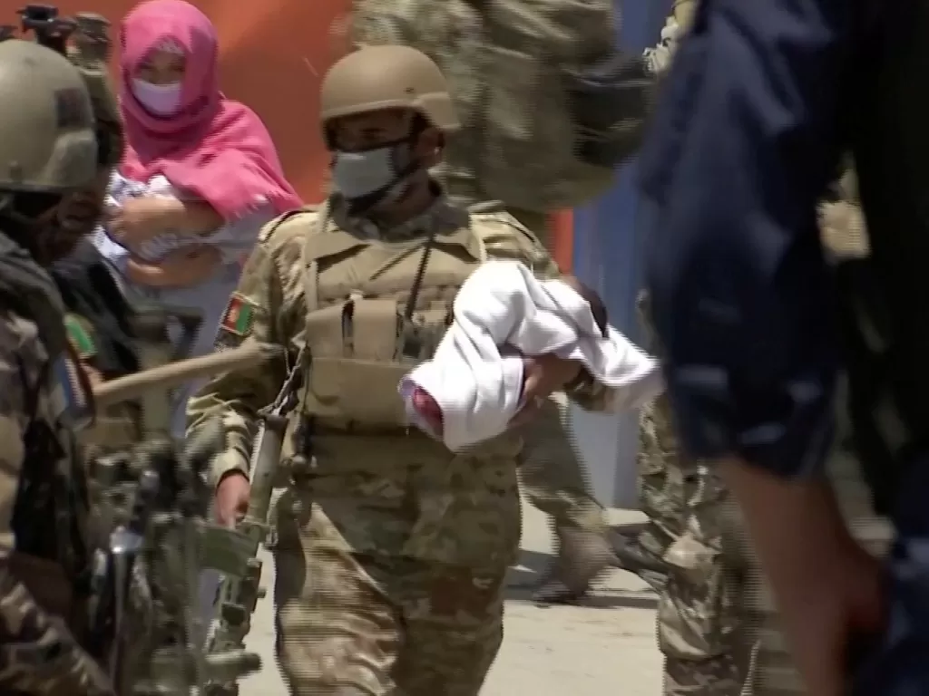 Personel keamanan Afghanistan mengevakuasi bayi dari rumah sakit di Kabul yang diserang. (REUTERS TV)