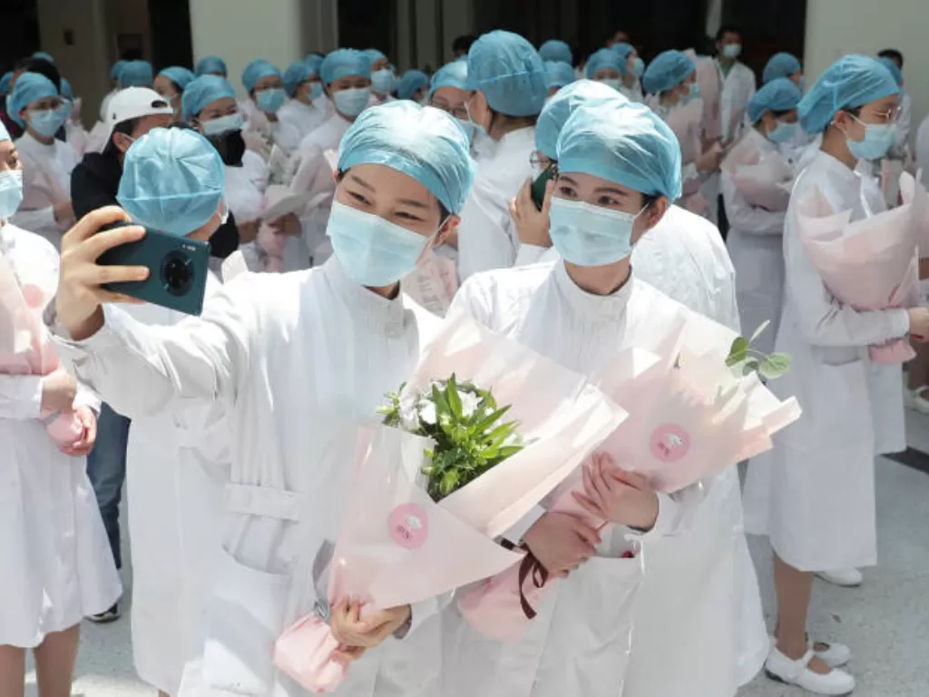 Perawat memakai masker berpose untuk foto saat berpartisipasi dalam sebuah acara untuk memperingati Hari Perawat Internasional, di Rumah Sakit Wuhan Tongji, provinsi Hubei, Tiongkok, Selasa (12/5/2020). (China Daily via REUTERS)