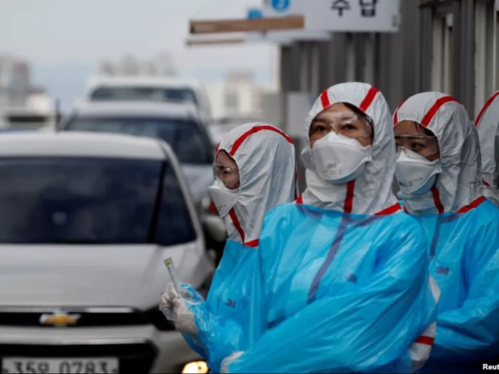 Petugas medis Korea Selatan melakukan tes Covid-19 terhadap para pengendara mobil. (REUTERS)