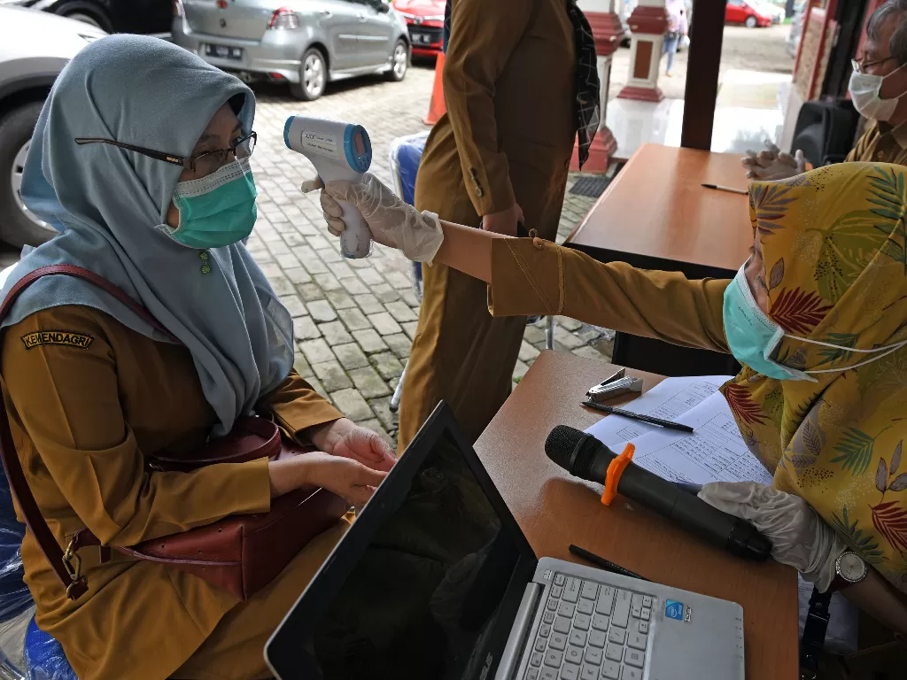 Petugas memeriksa suhu tubuh ASN (Aparatur Sipil Negara) Kota Serang saat melakukan rapid test (ANTARA FOTO/Asep Fathulrahman)
