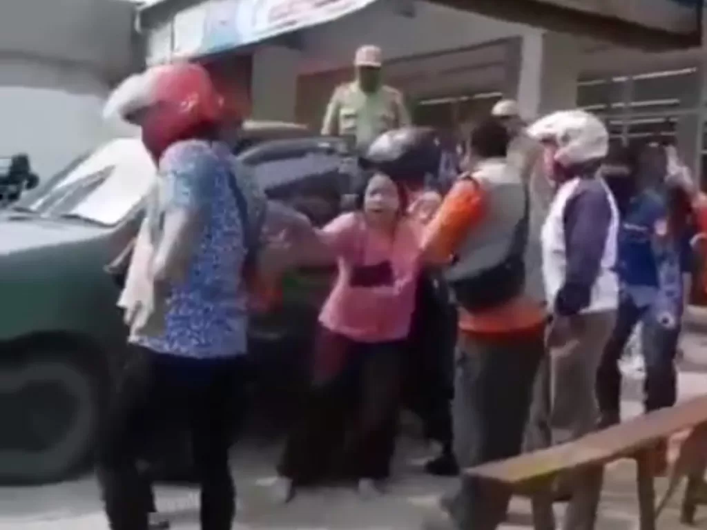 Istri penjual kopi menangis saat suaminya ditahan karena mengacungkan golok ke petugas PSBB di Bekasi. (Istimewa)