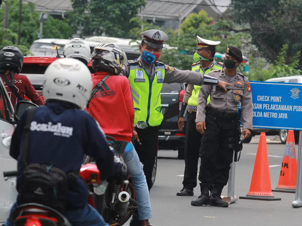 Petugas kepolisian melakukan pengecekan di cek point PSBB atau perbatasan Jakarta. (ANTARA/Muhammad Iqbal)