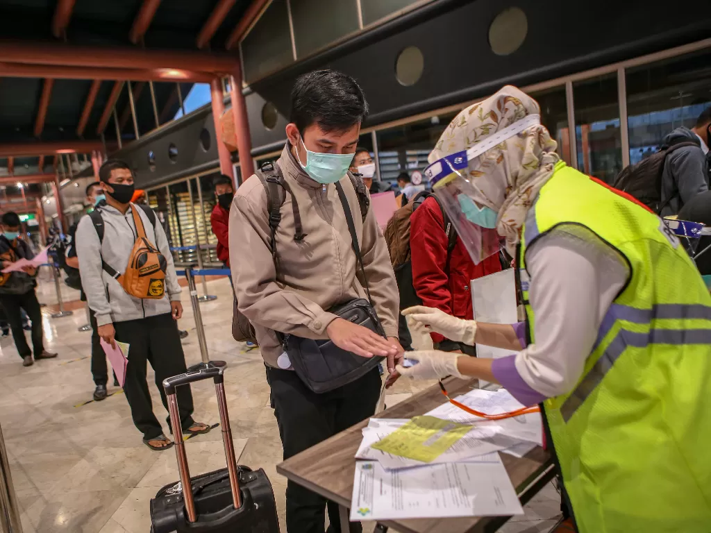 Petugas memeriksa kesehatan calon penumpang sebelum pemberangkatan di Terminal 2 Bandara Soekarno Hatta, Tangerang, Banten. (Foto ANTARA/Fauzan)