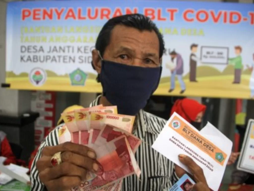  Warga menunjukkan uang Bantuan Langsung Tunai (BLT) dana desa di Balai desa Janti, Waru, Sidoarjo, Jawa Timur, Kamis (14/5/2020). ANTARA FOTO/Umarul Faruq/nz