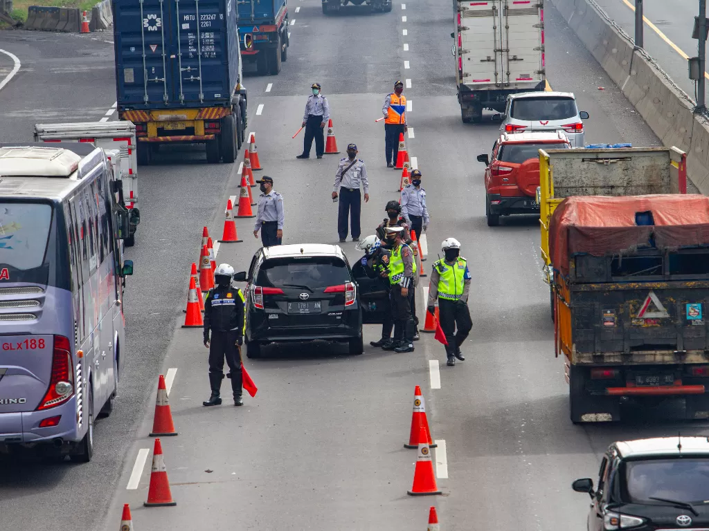 Petugas memeriksa kendaraan roda empat di Jalan tol Jakarta - Cikampek Km 47, Karawang, Jawa Barat, Rabu (6/5/2020). (ANTARA/M Ibnu Chazar)