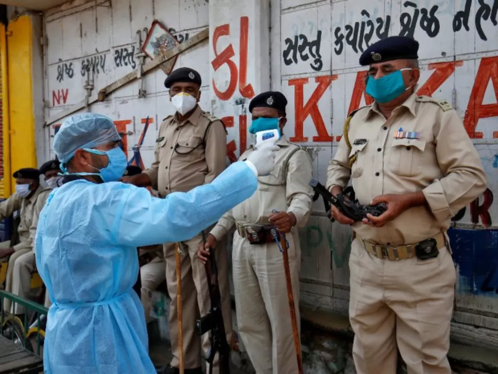 Polisi India diperiksa suhu tubuhnya. (REUTERS/Amit Dave)