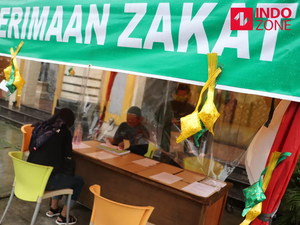 Warga menunaikan pembayaran zakat fitrah di Masjid Nurul Huda, Kebagusan, Jakarta, Senin (18/5/2020). (INDOZONE/Febio Hernanto)
