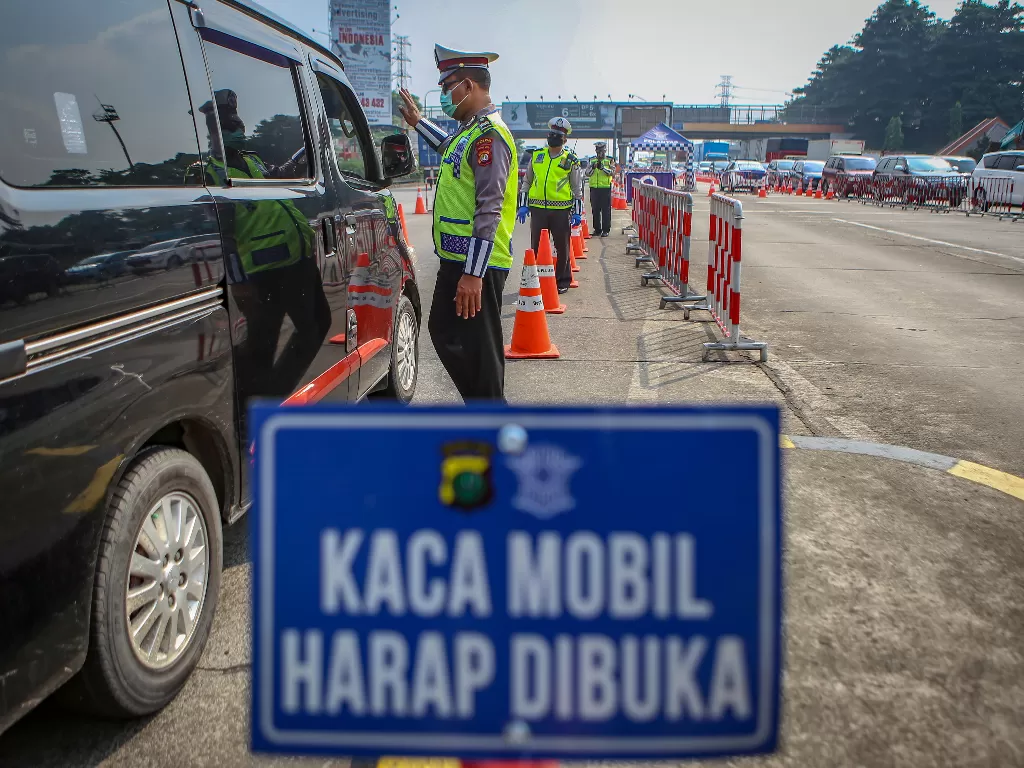 Petugas kepolisian memeriksa kendaraan di gerbang tol Cikupa, Kabupaten Tangerang, Banten, Selasa (19/5/2020). (ANTARA FOTO/Fauzan)