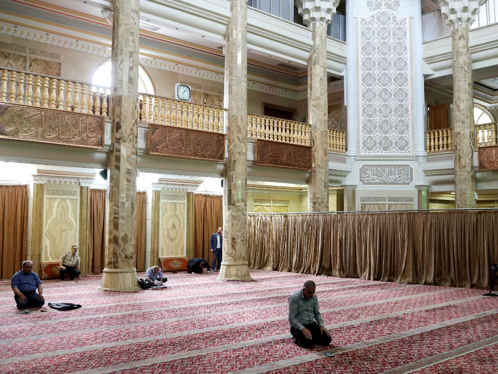 Para jamaah Iran berdoa ketika mereka menjaga jarak sosial di sebuah masjid setelah wabah Covid-19, di Teheran, Iran. (Photo/REUTERS/Ali Khara)