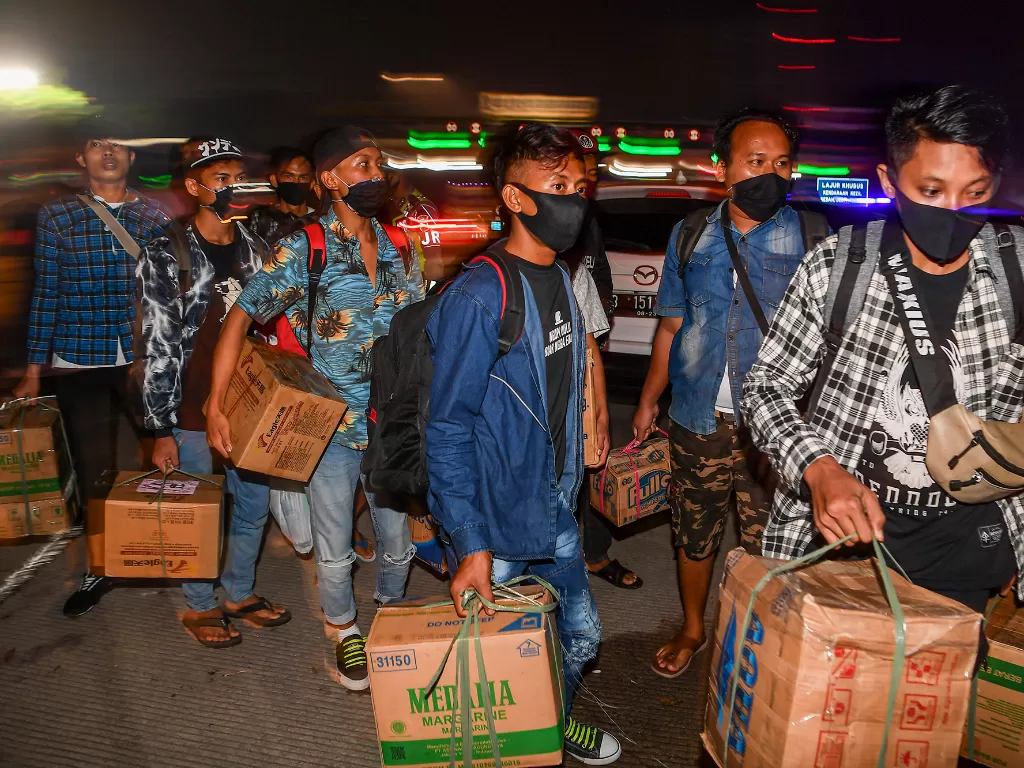  Calon pemudik yang terjaring razia penyekatan berjalan menaiki bus yang akan membawa mereka ke Terminal Pulogebang, Jakarta, di Pintu Tol Cikarang Barat, Bekasi, Jawa Barat, Kamis (21/5/2020). (ANTARA FOTO/Nova Wahyudi)