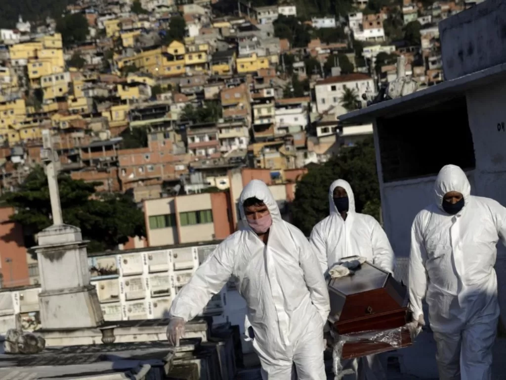 Penggali kubur membawa peti mati salah satu warga yang meninggal karena penyakit coronavirus (Covid-19), di Rio de Janeiro, Brasil, Senin (18/5/2020). (REUTERS/Ricardo Moraes)