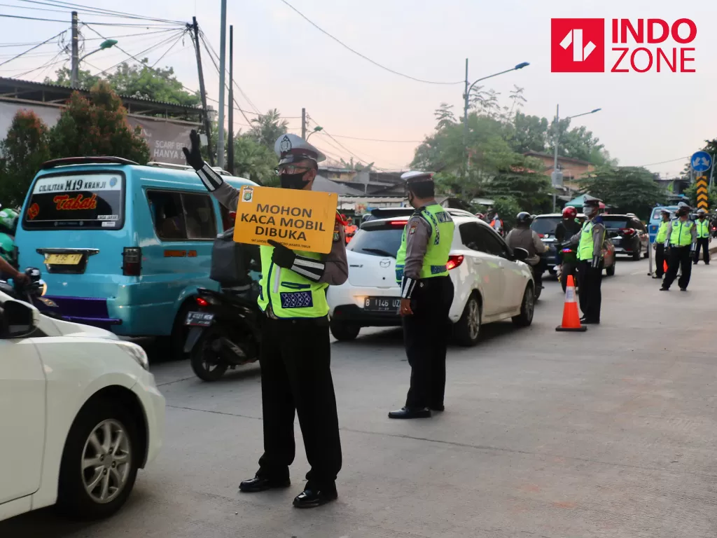 Petugas kepolisian memeriksa kendaraan saat pemberlakuan SIKM yang melintas di cek poin Lampiri, Kalimalang, Jakarta, Jumat (22/5/2020). (INDOZONE/Febio Hernanto)