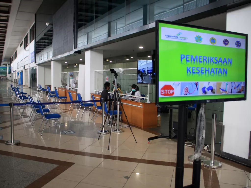 Petugas Kantor Kesehatan Pelabuhan (KKP) Kelas 1 Surabaya memeriksa kelengkapan surat perjalanan dan kesehatan seorang calon penumpang di Terminal 1 Bandara Internasional Juanda, Sidoarjo, Jawa Timur, Sabtu (23/5/2020). (ANTARA FOTO/Umarul Faruq)