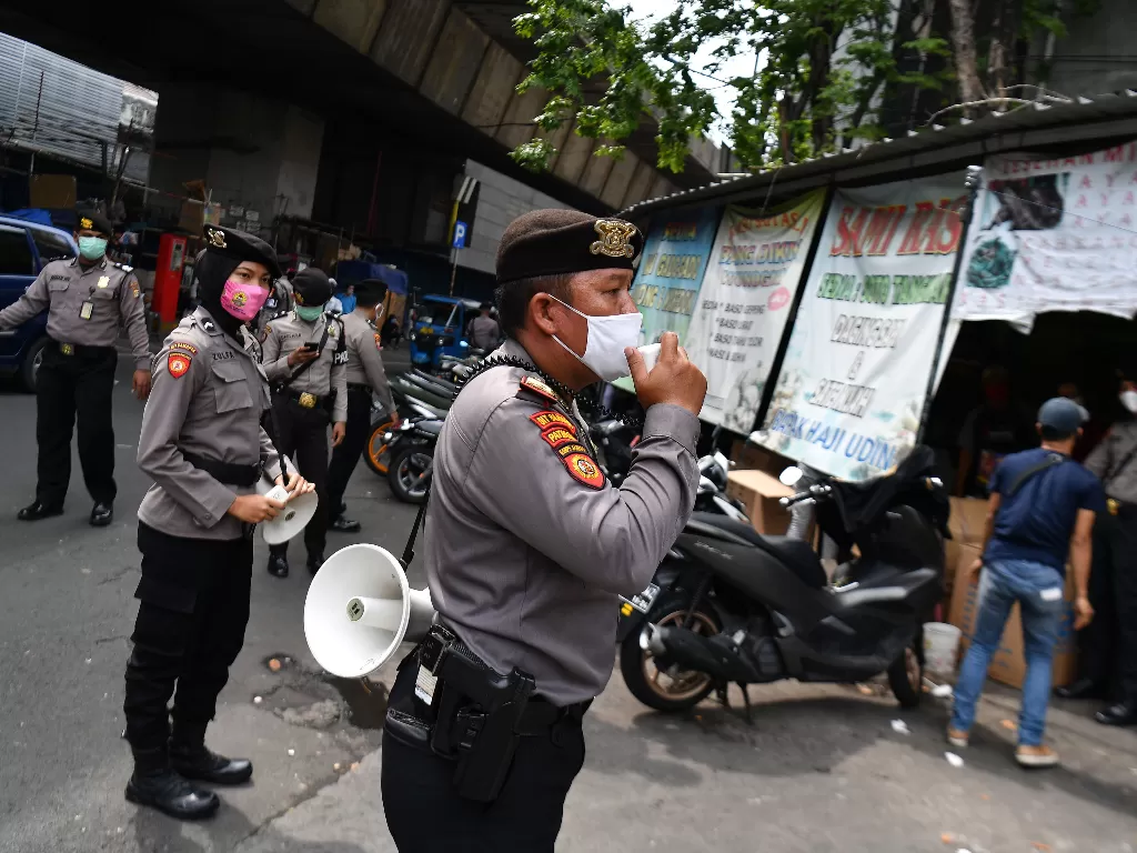 Anggota Ditsamapta Polda Metro Jaya melakukan sosialisasi protokol kesehatan di Pasar Pagi Asemka, Jakarta Barat, Rabu (27/5/2020). (ANTARA FOTO/Sigid Kurniawan)